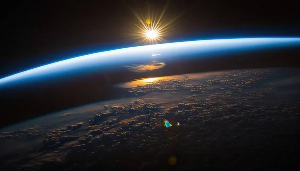 the sun is shining over the earth as seen from space.