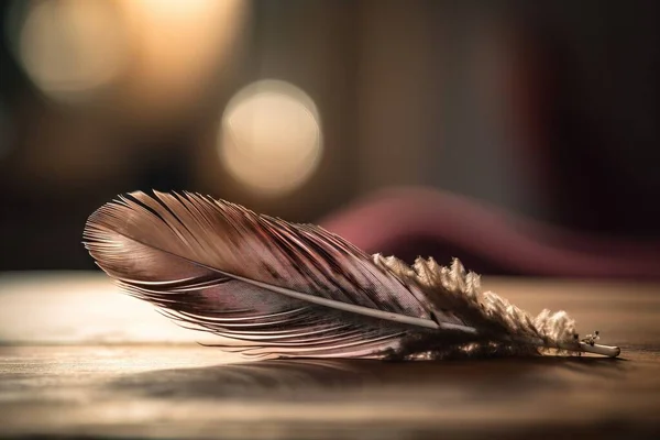 a close up of a feather on a wooden table with a blurry background.