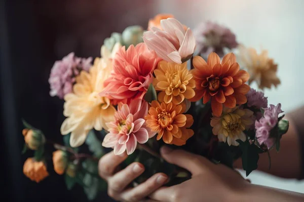 a person holding a bunch of flowers in their hands with a blurry background.