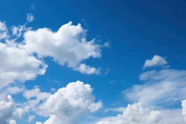 a blue sky with white clouds and a plane flying in the sky with a blue sky in the background and a few white clouds in the sky.