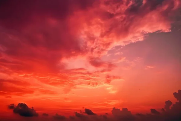 a red sky with clouds and a plane flying in the sky at sunset or sunset time with a plane in the foreground and a plane in the foreground.