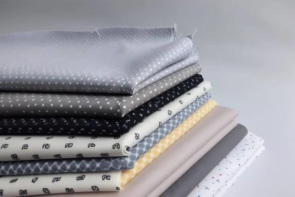 a stack of folded sheets sitting on top of a table next to each other on top of a tablecloth covered in polka dotes.