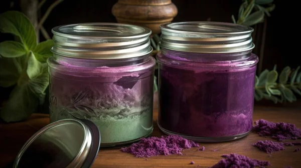 a couple of jars filled with purple and green stuff on a table.