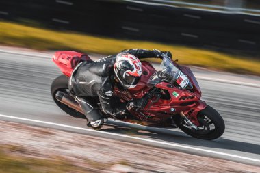  Virajlı bir yolda kırmızı motosiklet süren bir adam. üretici ai