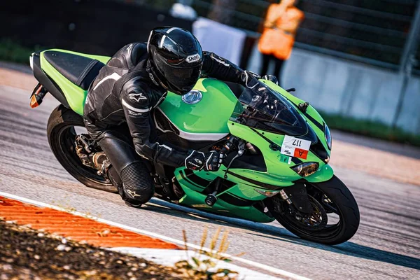 ヘルメットを搭載したレースコースで緑色のオートバイに乗っている人 ジェネレーティブ エイブ — ストック写真