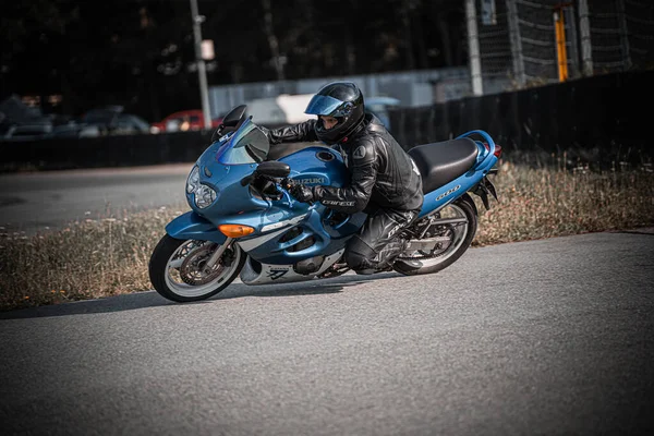 背の高い草の隣の通りで青いバイクに乗っている男 ジェネレーティブ エイブ — ストック写真
