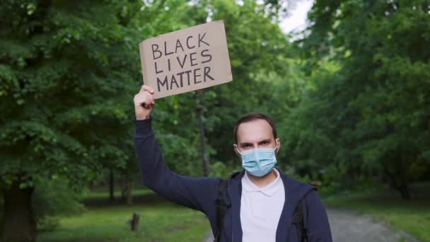 Hombre Enmascarado Sostiene Cartón Con Las Palabras Black Lives Matter — Vídeos de Stock