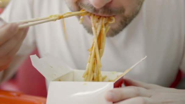 Seorang Pria Dalam Shirt Putih Makan Mie Udon Dengan Ayam — Stok Video