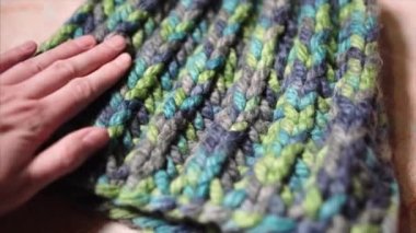 Kadın almadan önce şapkanın kalitesini kontrol eder. Büyük, bağlayıcı Brioche Stitch akrilik, sentetik koyun ipi seçen bir alıcının eli. Renkli Merino Wool. 4k ultraHD görüntüler.