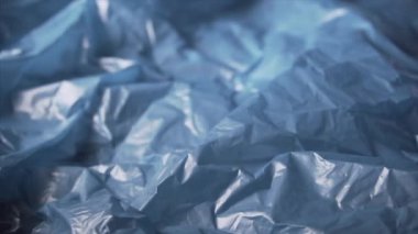 Slow pan of a blue plastic garbage bag, concept of pollution of the environment with plastic waste. Close up shot.