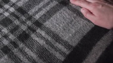 Close-up of checkered acrylic or wool fabric, womens sweater or scarf, monochrome palette. Slow pan shot.