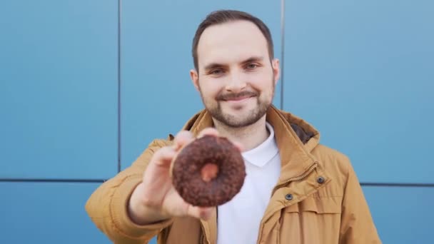 Cheerful Smiling Bearded Man Shows Chocolate Doughnut Camera Footage — Vídeo de Stock