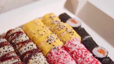 General view of the set of different five rolls from the delivery: philadelphia, maki roll, with tobiko caviar, salmon, tuna, mussels and shrimps and other assorted. Ultra HD footage.