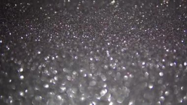 Shiny grey and silver sparkling light particles, blurry abstract unfocused background, texture for creative use 4k.