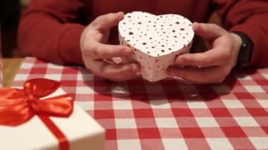 Man prepared a gift for the holiday for girlfriend and is going to present it for an important event: a holiday, an anniversary, Valentines Day, a marriage proposal, a declaration of love. 4k close