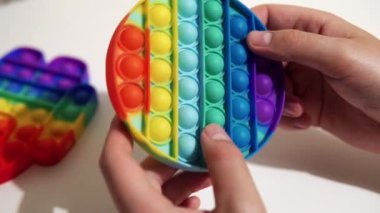 Man rotates the popular silicone anti-stress toy pop it, a multi-colored tactile trendy toy.