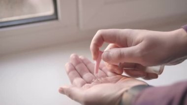 Mens hands in smartwatches rub in the palms of the antibacterial alcohol gel sanitizer. Close up shot 4k.