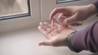 Young man rubs in hands antibacterial alcohol gel sanitizer. Close up shot 4k.