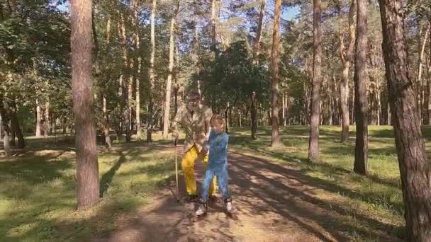 Little Girl Rollerblading Park Her Old Grandfather Holding Her Hand — Stockvideo