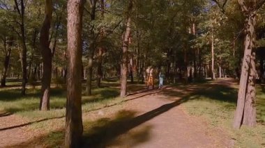 Old grandfather is roller skating. Granddaughter roller-skating with grandfather.