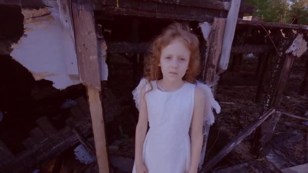 在一座被烧毁的房子的背景下 可怜的小女孩 被毁房屋附近的儿童天使 — 图库视频影像