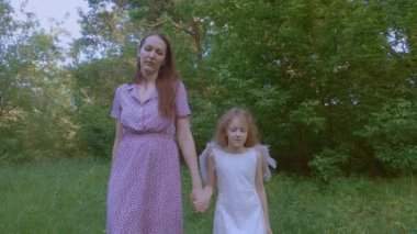 Anne ve kızı parkta yürüyüp konuşuyorlar..