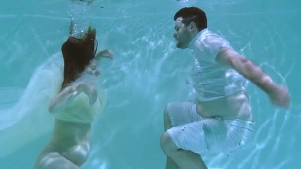 女と男が水中で泳いでいる 女性が水中で男にキス — ストック動画