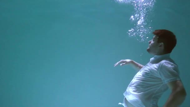 穿着衣服的人在水下打滚 他沉入水中 — 图库视频影像