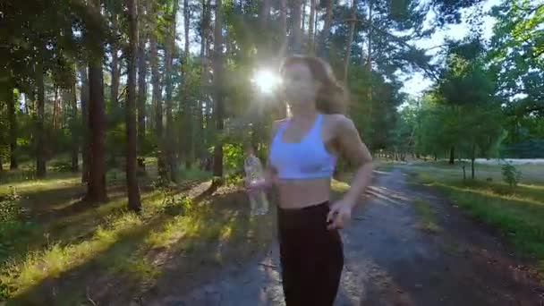 公園のトレーニングカーディオで走る運動女性 ジョギングは重い負荷の前にウォームアップです 公園で屋外で走ることは女性にとって有益です — ストック動画