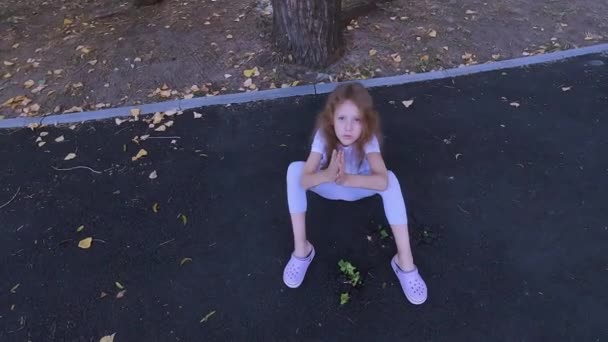 Egy Kislány Gondját Viseli Egy Fanövénynek Ami Aszfaltján Keresztül Csírázik — Stock videók