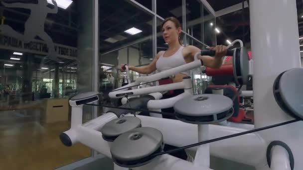 Mujer Gimnasio Entrena Máquinas Musculación Una Mujer Bombea Sus Músculos — Vídeo de stock