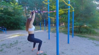 Spor salonundaki kadın vücut geliştirme makineleriyle antrenman yapıyor. Bir kadın kaslarını simülatöre pompalıyor. Kadın vücudunu spor makinesinde çalıştırmak.