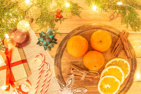 stock image Christmas decoration with tangerines, cinnamon, fir branches, gift and Christmas toys.