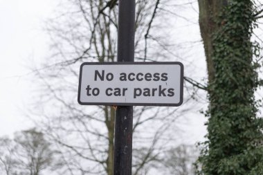 no access to car parks sign.  White sign for vehicle drivers
