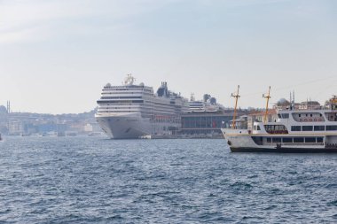 İstanbul, Türkiye 22 Ekim 2023, Boğaz, Galataport 'ta yolcu gemileri ve turistlerle birlikte yüzen küçük gemiler. Arka planda büyük bir cami.