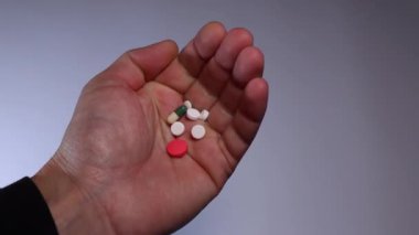 Erkeklerin elinde farklı renk ve şekillerde haplar var.