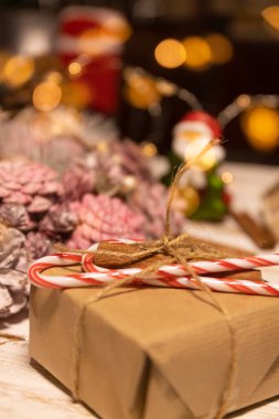 Geri dönüşümlü kağıt ve sicimle doldurulmuş Noel hediyesi. Noel süslemesi beyaz ahşap masada