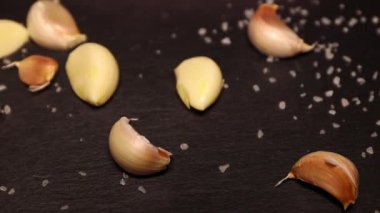 Sarımsak karanfilleri siyah taş bir levhada. yavaş çekim.