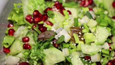 Meyve ve sebzeli taze salata. Marul, roka, bebek ıspanak, salatalık, nar, zeytin ve taze soğan karışımı ve zeytinyağı ile karıştırılmış.
