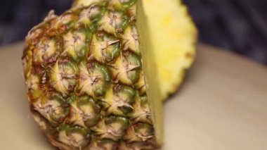 Ahşap bir masada yakın plan iki ananas kes. Yarım yamalak meyve ananası kesimi. Ananasın lifleri, potasyum ve C vitamini hepsi kalp sağlığını destekliyor.