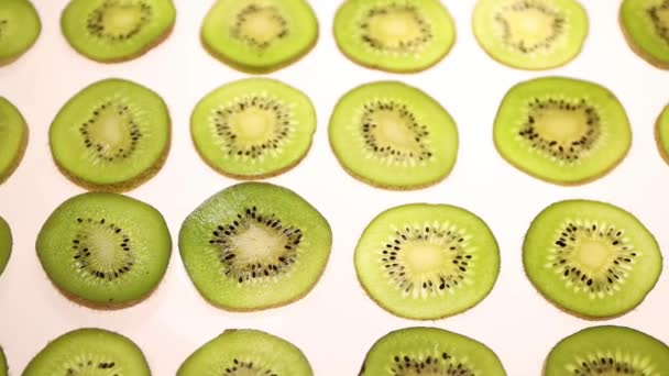 Vers Gesneden Schijfjes Kiwi Witte Tafel Bovenaanzicht Slow Motion Kiwi — Stockvideo
