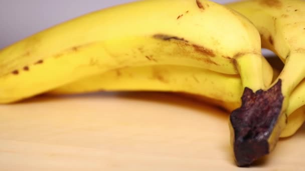 木のテーブルのゆっくりした動きのフルーツ バナナを熟して下さい バナナスは 心臓の健康を高め 血圧を管理するのに役立つ重要な栄養素が含まれています そして 人の気分を高めます 他の利点の中で — ストック動画