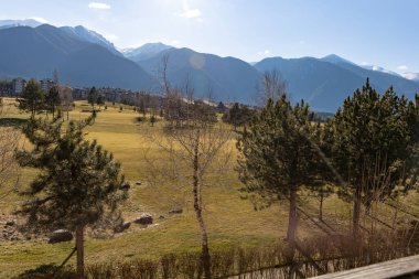 Razlog, Bulgaristan, 16 Şubat 2024. Pirin golf sahası, otel alanı ve Pirin Dağı 'nın karlı zirveleri. Pirin ve Rila 'daki arazi, dik yamaçlardaki patikaları da kapsıyor..