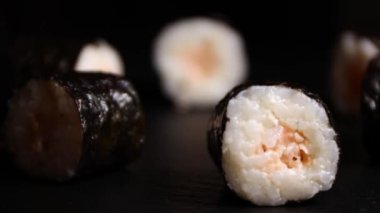 Dönüşümlü hosomaki suşi ruloları, soya sosu ve yemek çubukları, yakın çekim. Pirinçli yemek, ağır çekim.
