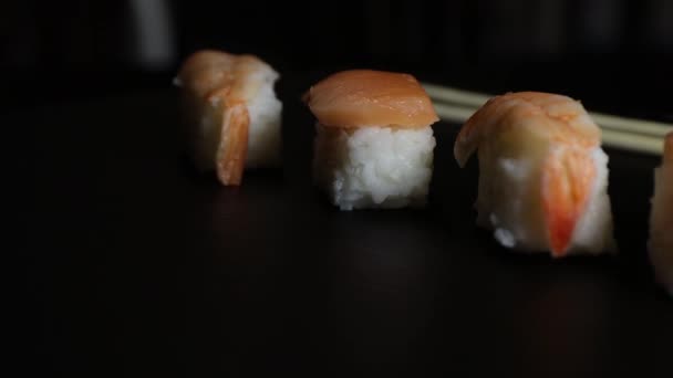 寿司黑鬼与煮虾和生鲑鱼在一个黑色盘子 米饭和海鲜食品 — 图库视频影像