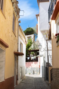 5 pril, 2024, Kavala Yunanistan. Yunanistan 'ın Kavala kentinde, renkli evlerle dolu dar bir sokak resmi