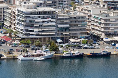5 Nisan 2024. Kavala, Yunanistan. Kavala limanındaki sahil caddesinin bir kısmı, binalar ve botlar