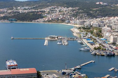 5 Nisan 2024. Kavala, Yunanistan. Kavala şehrindeki sahil caddesinin bir kısmı, liman binaları ve botlar, yatay resim.