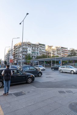 Selanik, Yunanistan, 23 Ekim 2024. Deniz kenarındaki bir bulvarda ve gezinti alanında araba trafiği. Selanik 'in turizm beldesinde dükkanlar ve konut binaları.