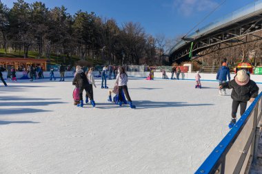 15 Aralık 2024, Bükreş, Romanya. Drumul Taberei Parkı 'ndaki buz pateni pistinde insanlar buz pateninin keyfini çıkarıyor.